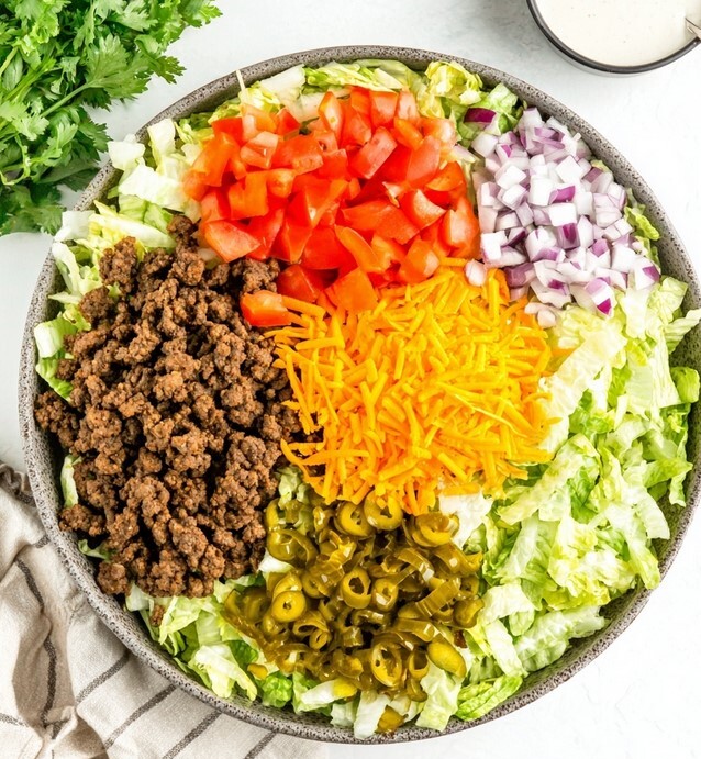 Low-Carb Big Mac Salad Ingredients - fresh lettuce, cooked beef, tomatoes, and cheese arranged in a bowl ready to mix.