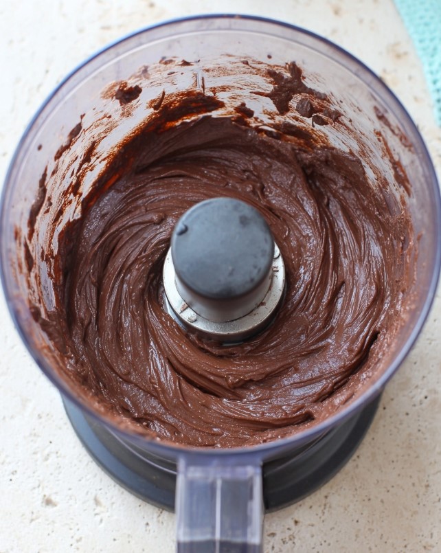 Image of the thick, smooth chocolate avocado mixture inside a food processor before chilling