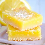 Zesty Keto Lemon Bars: The Ultimate Bakery Style Low Carb Dessert Finished lemon bars after baking and cooling, with a lemon custard layer over a biscuit base and a dusting of powdered sugar.