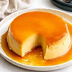A firm, ready-made creme caramel topped with a shiny layer of golden caramel, with a slice cut out to reveal the ultra-smooth, creamy interior texture.