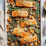 The Ultimate Sheet Pan Salmon with Vegetables (With a Honey Tahini Glaze) A complete sheet pan dinner featuring roasted salmon fillets glazed in tahini, surrounded by golden sweet potato cubes, roasted mushrooms, and vibrant green beans, ready to serve.