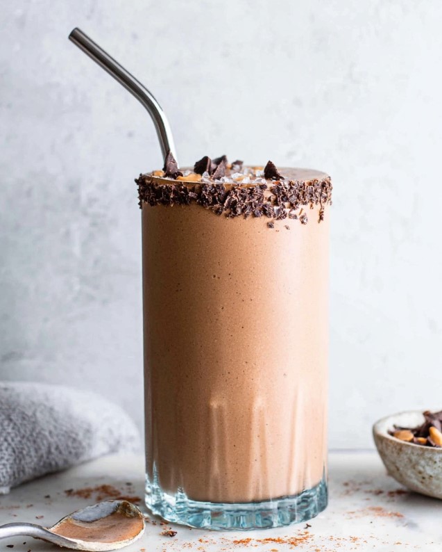 A decadent chocolate smoothie served in a glass, garnished with dark chocolate chips.