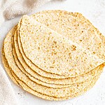 A stack of warm, golden-brown keto tortillas fresh off the skillet, ready to be filled.