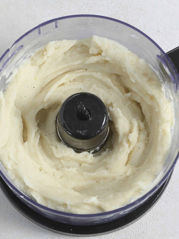 The cauliflower mixture inside the food processor, now blended into a smooth, silky consistency