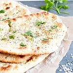 Soft & Buttery Keto Garlic Naan (Better Than Takeout) Naan ready to serve after baking with a touch of herb and seed garnish.