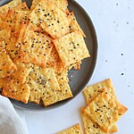 Golden baked crackers cut into squares, fresh from the oven and sprinkled with seeds.