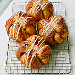 Flaky Salted Maple Pumpkin Spice Cruffins in 35 Minutes Golden baked salted maple pumpkin spice cruffins on a wire cooling rack with white cream cheese drizzle and flaky sea salt